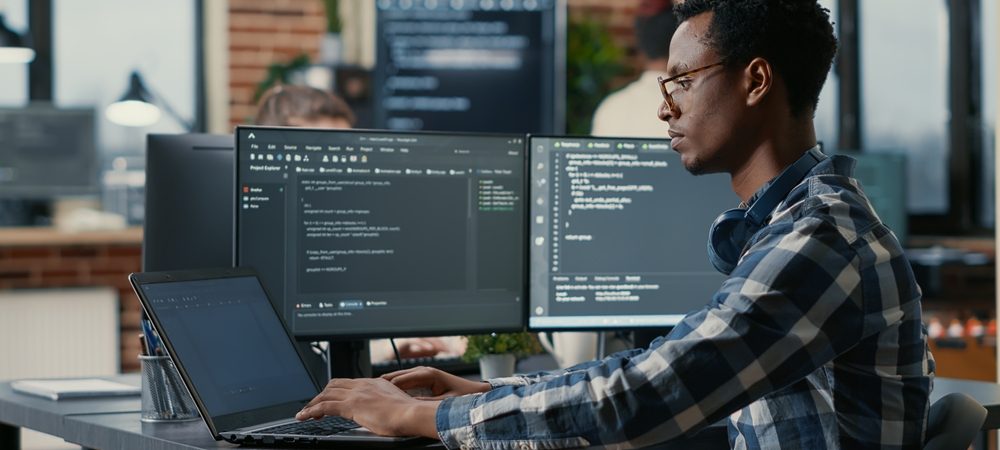 Portrait,Of,African,American,Developer,Using,Laptop,To,Write,Code